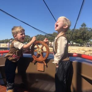 Kids playing with the steering wheel at the front of the vessel